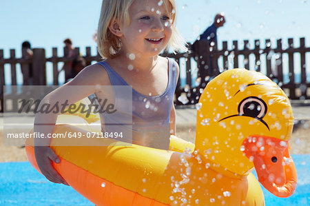 Child with duck-shaped float in pool