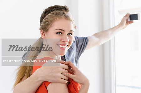 Close up of young couple taking photograph from window Close up of young couple taking photograph from window