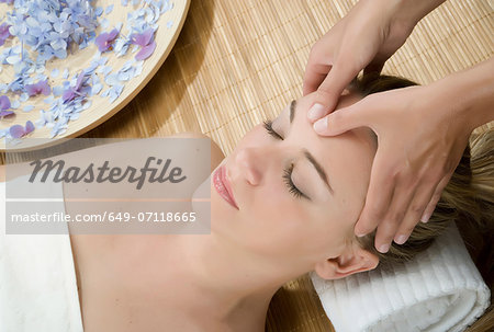 Woman at spa having forehead massaged