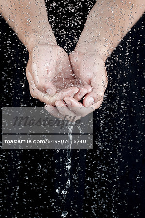 Cupped hands holding water with droplets