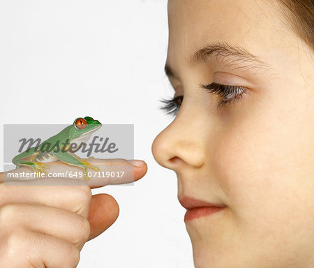 Girl with a red-eyed tree frog on her finger