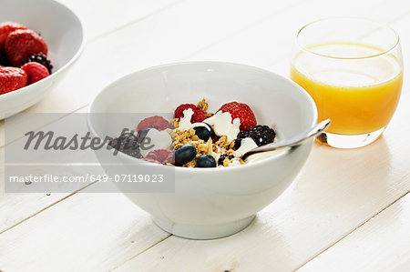 Breakfast cereal with fresh berries and orange juice