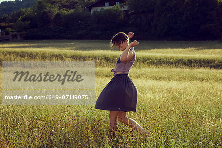 Young woman walking through meadow