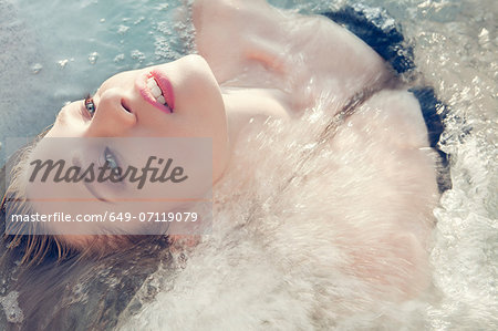 Close up portrait of young woman lying back in sea