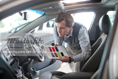 Mid adult man with color swatch in car showroom