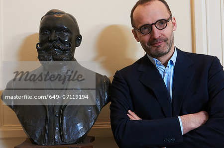 Portrait of confident professional man next to statue