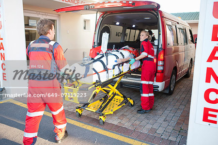 Paramedics lifting patient from ambulance