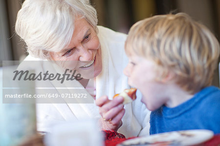 Grandmother feeding grandson breakfast