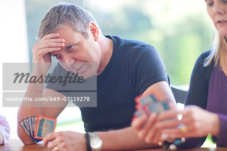 Mature male playing cards with family