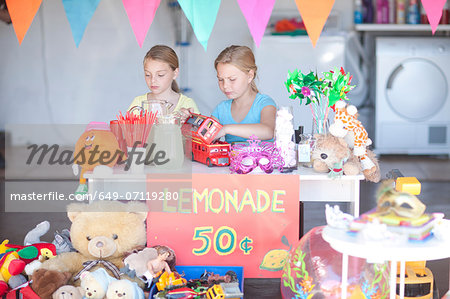 Two young sisters setting up stall