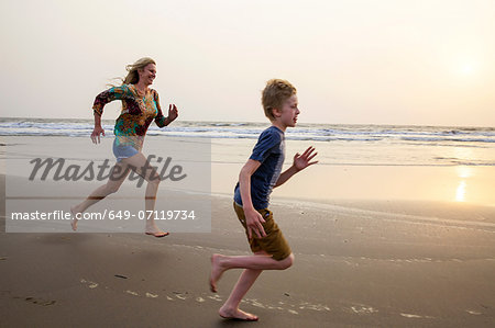 Mother and son running on beach Mother and son running on beach