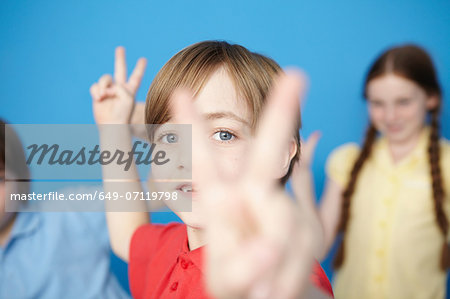 Portrait of boy making peace sign