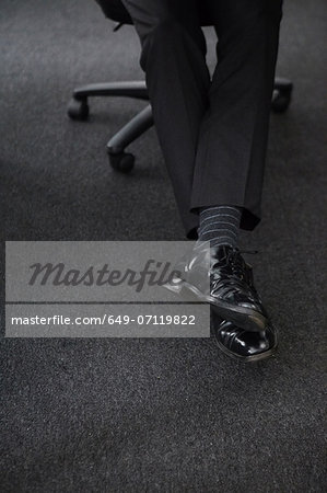 Businessman wearing black shoes and trousers, low section