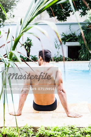 Man sitting at poolside