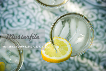 Making Lemonade. Overhead Shot Of Lemonade Glasses With A Fresh Slice Of Lemon In The Edge Of The Glass. Organic Lemonade Drinks.