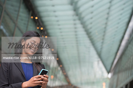 Business People. A Young Woman In A Blue Dress And Grey Jacket.