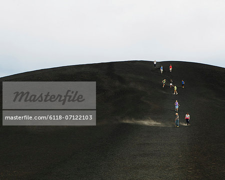 A Black Volcanic Cone Hillside In The Craters Of The Moon National Monument And Preserve In Butte County Idaho. People Walking On The Slope.