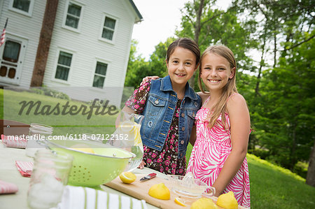 A Summer Family Gathering At A Farm. Two Children Standing Side By Side. Making Homemade Lemonade. A Summer Family Gathering At A Farm. Two Children Standing Side By Side. Making Homemade Lemonade.