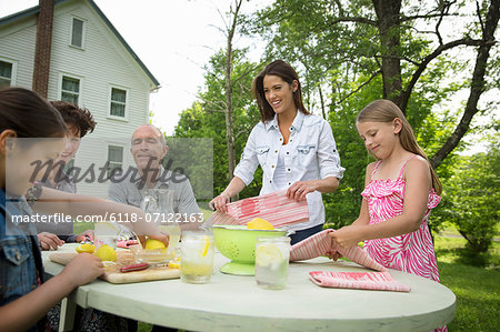 A Summer Family Gathering At A Farm. A Family Group, Parents And Children. Making Fresh Lemonade.