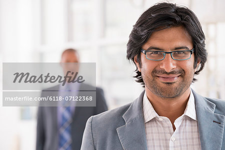 Business People. A Man In A Light Jacket Wearing Glasses.
