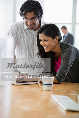 Office. A Man And A Woman Using A Laptop Computer.