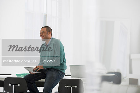 Business. A Man Leaning On A Desk Holding A Digital Tablet.