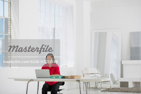 Light And Airy Working Environment. A Woman Seated Using A Laptop.