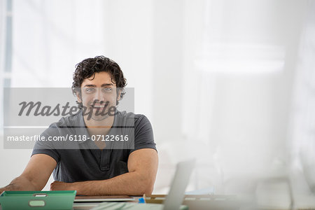 Business. A Man Sitting In A Relaxed Pose Behind A Desk.