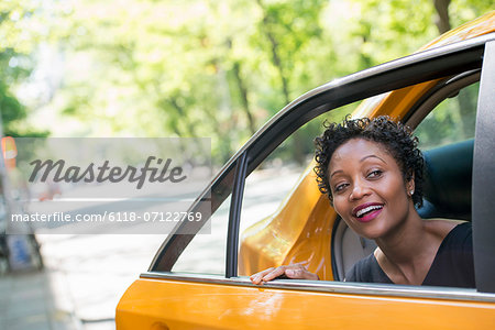 A Woman Getting Out Of The Rear Passenger Seat Of A Yellow Cab.