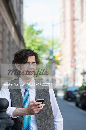 A Young Business Man On The Street Checking His Smart Phone.