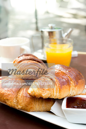 Breakfast with coffee and croissants in a basket on table