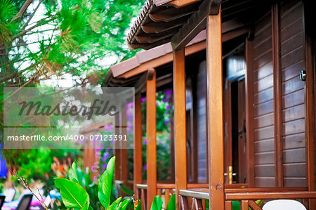 Wooden balconies bungalows in a tropical garden.