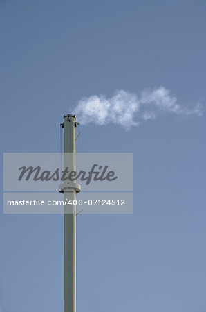 Smokestack in front of gray background. Vertical.
