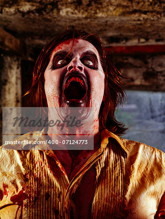Photo of a bloodied zombie with its mouth open wide ready to bite.