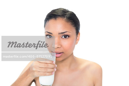 Charming young dark haired model drinking milk on white background
