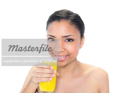 Happy young dark haired model drinking orange juice on white background