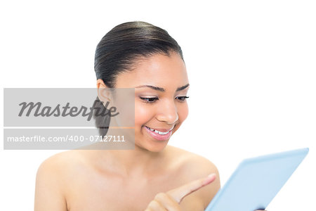 Concentrated young dark haired model using a tablet pc on white background