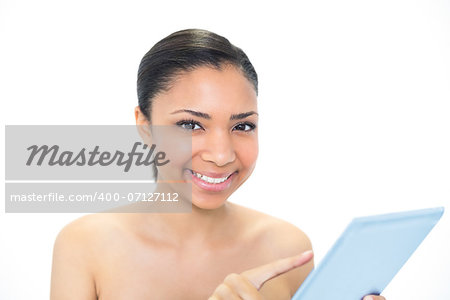 Smiling young dark haired model using a tablet pc on white background