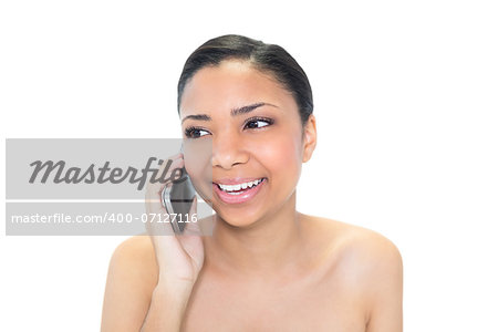 Thoughtful young dark haired model making a phone call on white background