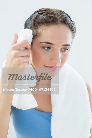 Close up of a young woman wiping sweat with towel