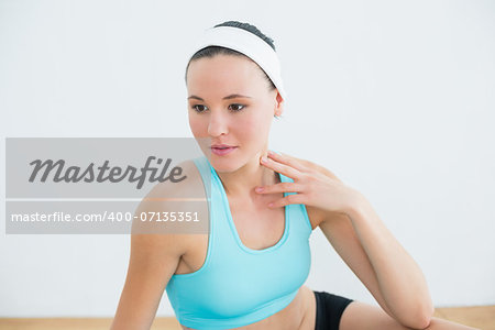 Close up of a thoughtful toned woman in fitness studio