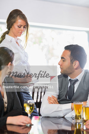 Business people ordering a dinner from waitress in the restaurant