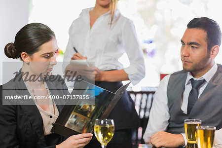 Businesswoman looking at menu in restaurant