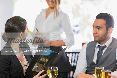 Businesswoman ordering dinner from smiling waitress in a restaurant