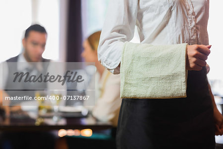 Waitress standing in front of two business people talking in a restaurant