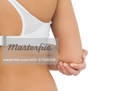 Rear view of young woman touching her injured elbow on white background
