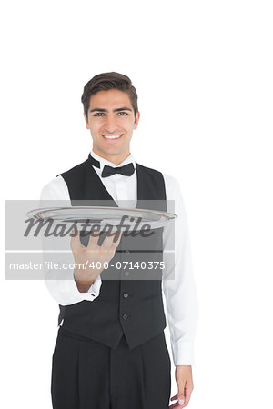 Young waiter presenting an empty tray smiling at camera