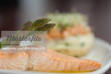 Close up of salmon dish with asparagus on white plate