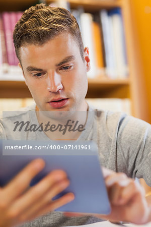 Attractive focused student using tablet in library