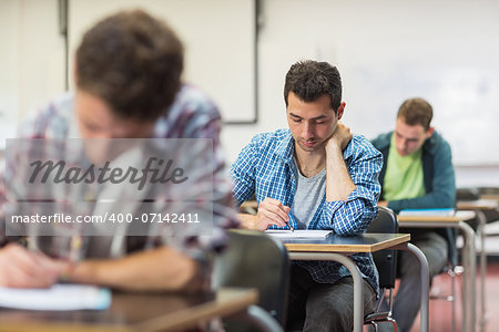 Group of young students writing notes in the classroom